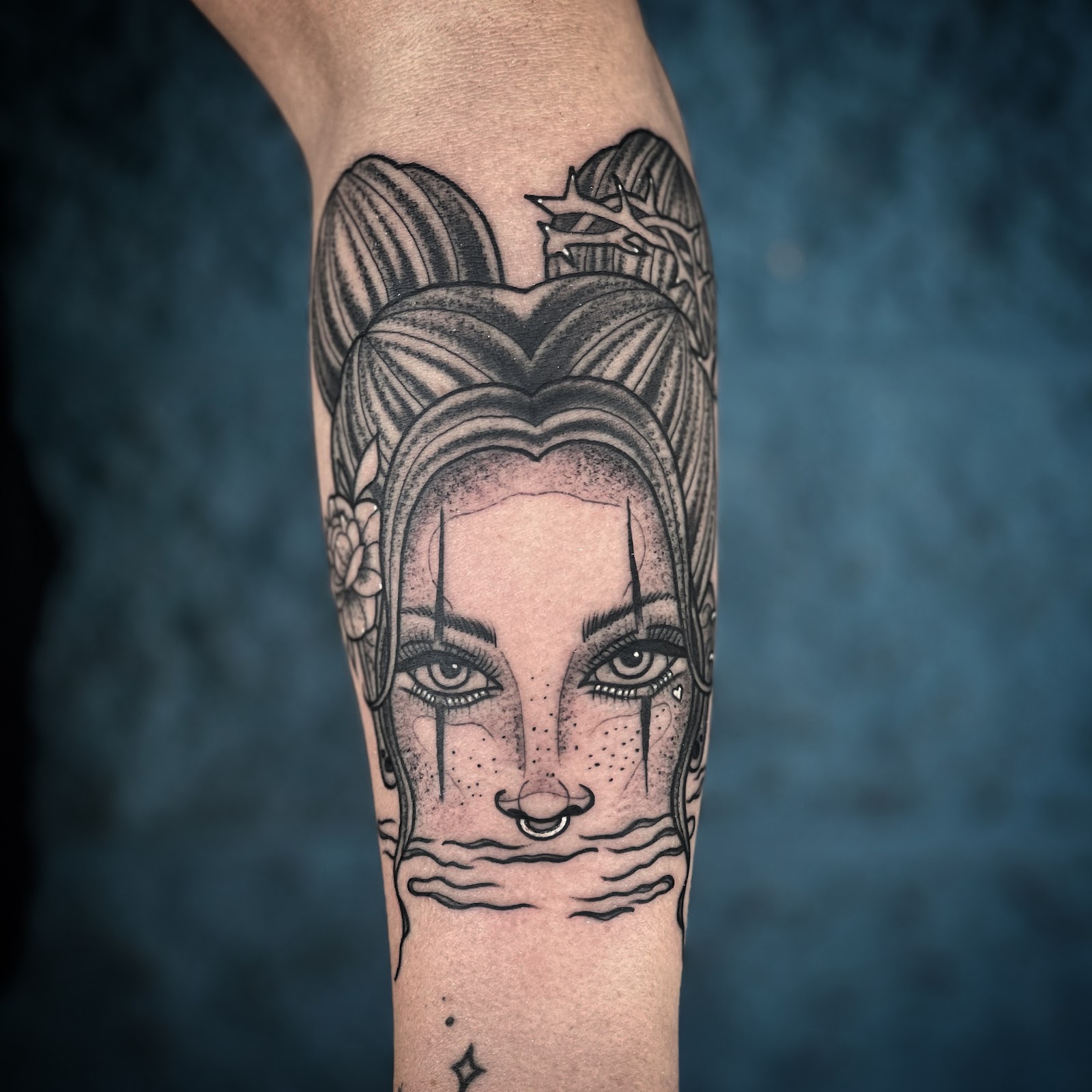 Black and grey portrait tattoo of a woman with a septum ring, on a forearm